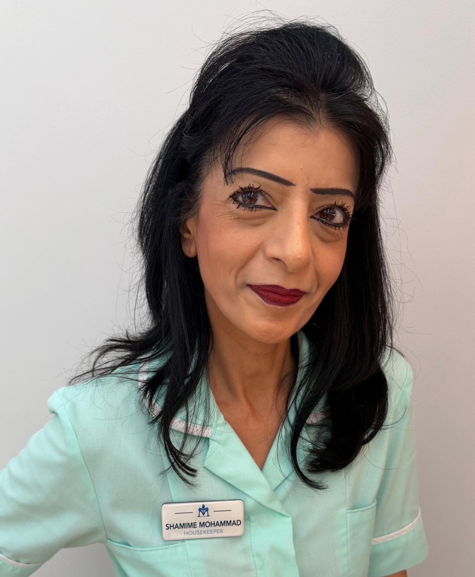 Woman with black hair in turquoise nurse uniform