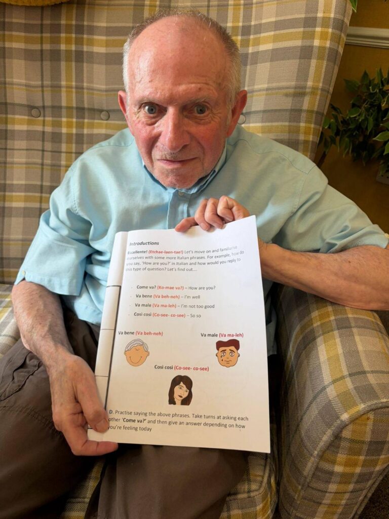elderly care home resident learning Italian from a textbook