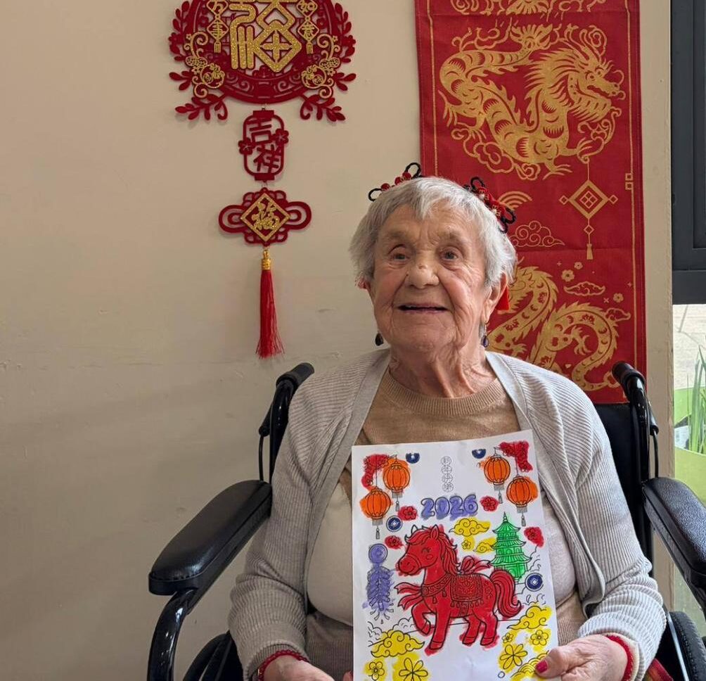 resident smiling with their chinese new year themed colouring page