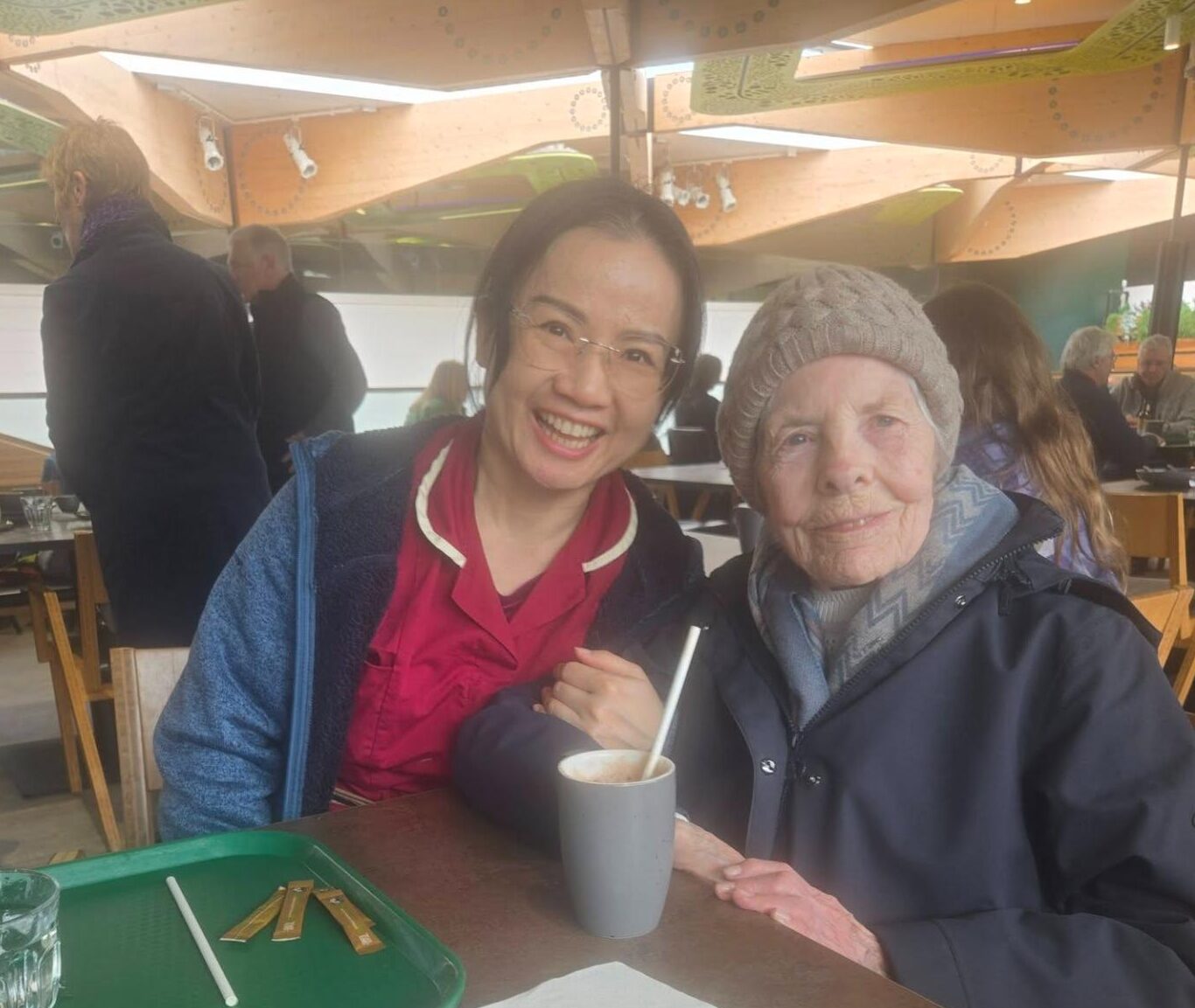 resident and staff smiling in a garden centre safe