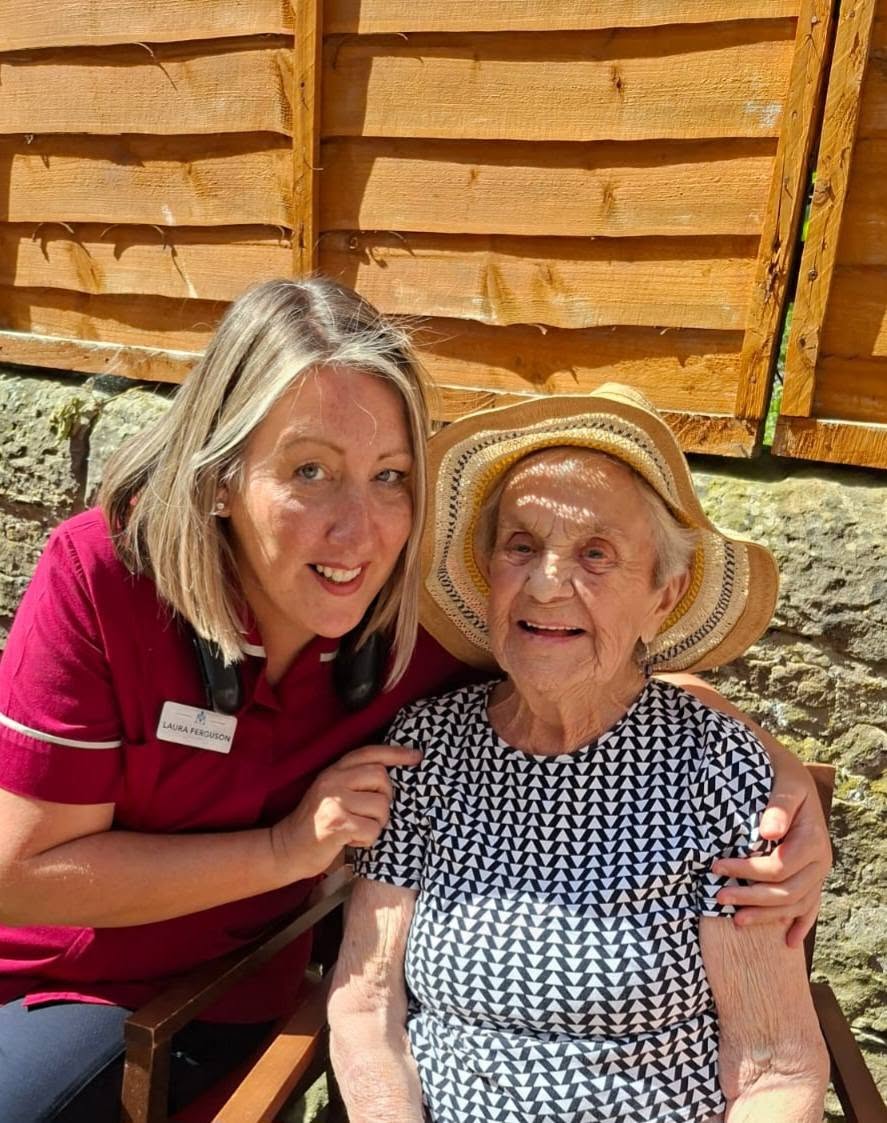 older lady in wheelchair with carer