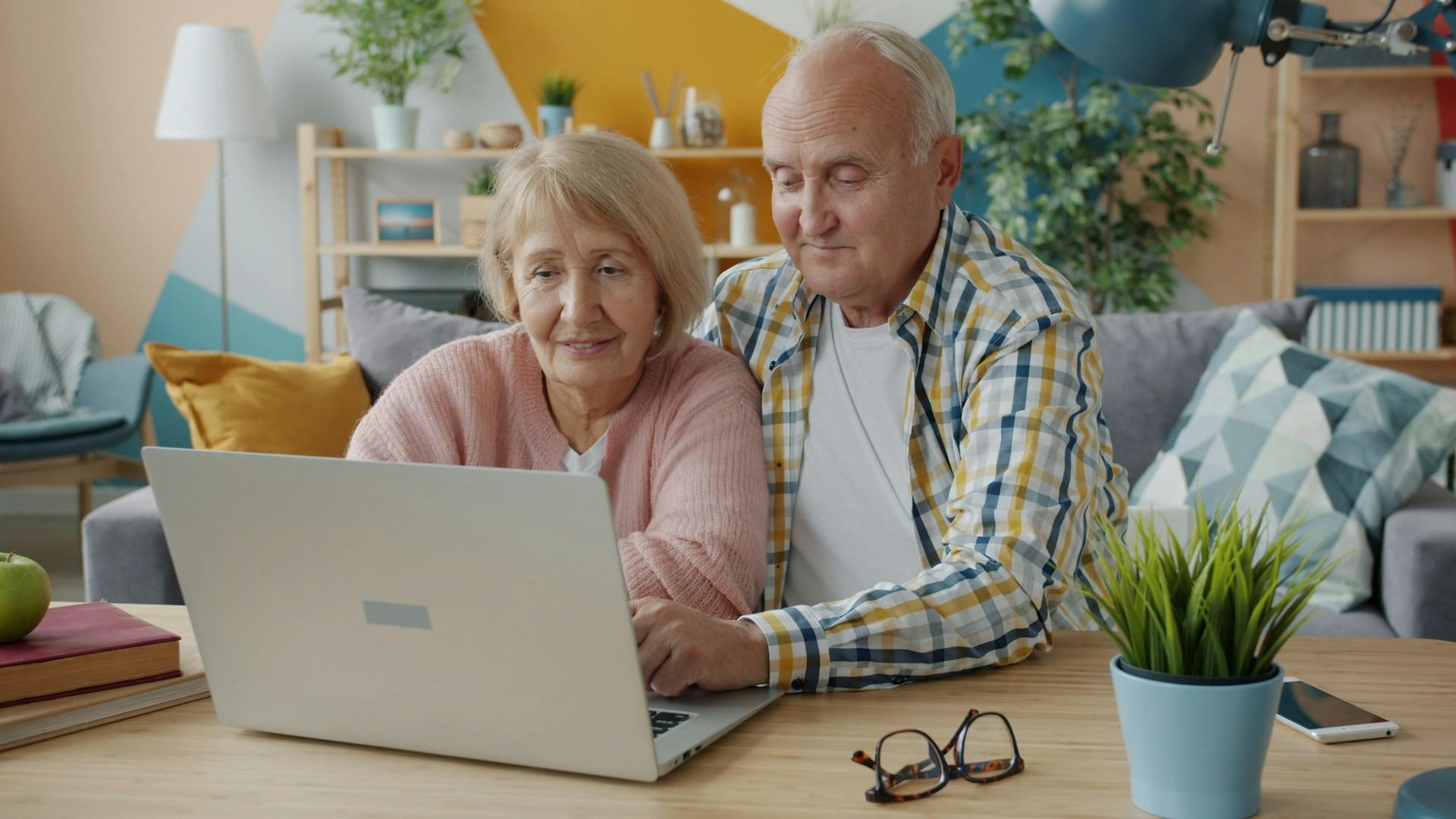 elderly couple using a laptop together
